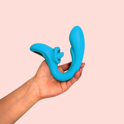 Vibrador Cáliz de Eva variante color azul turquesa en forma de argolla, sostenido en la mano - Edén