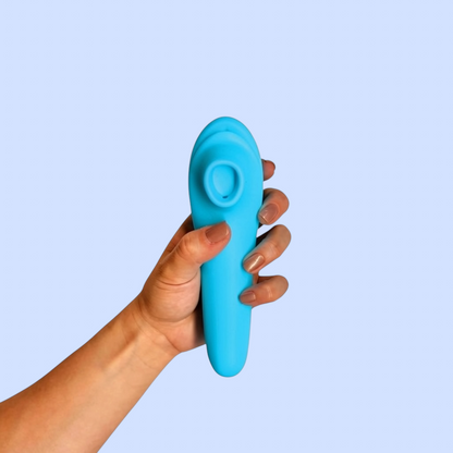 Succionador Capullo Rosado variante color azul turquesa, sostenido en la mano - Edén