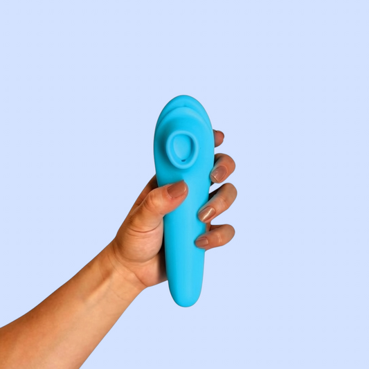 Succionador Capullo Rosado variante color azul turquesa, sostenido en la mano - Edén
