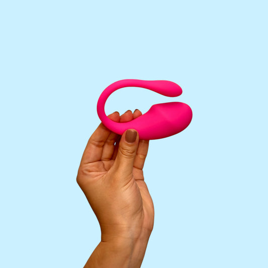 Vibrador Cisne del Jardín color fucsia en forma de U, sostenido en la mano - Edén