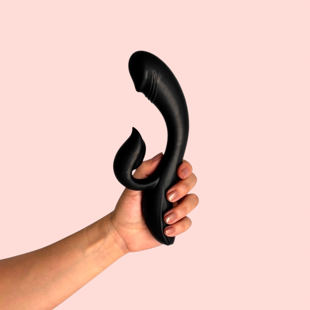 Vibrador Pétalo de Fuego variante color negro con brazo estimulador en forma de llama, sostenido en la mano - Edén