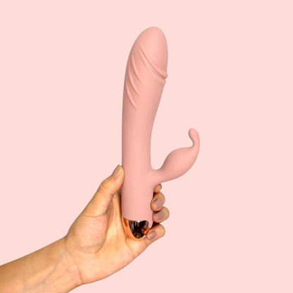 Vibrador Rocío del Alba variante color rosa nude con base metálica, sostenido en la mano - Edén